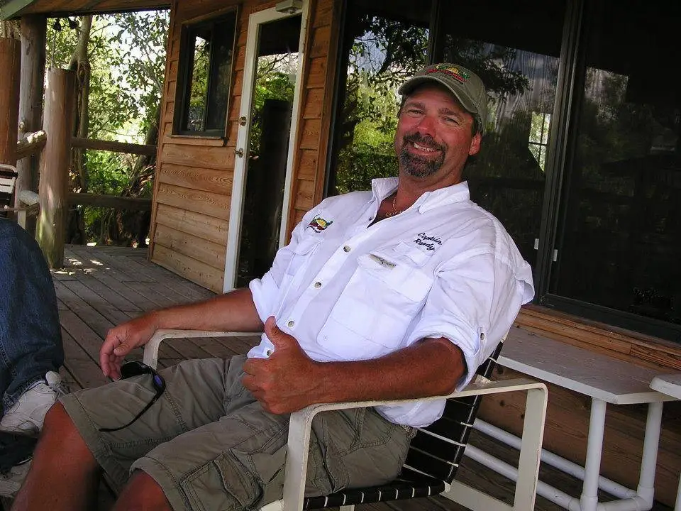 Captain Randy guiding an Everglades airboat charter through the wetlands with guests onboard.