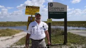 Captain Randy standing by the Everglades and Francis S. Taylor Wildlife Management Area sign, guiding private Everglades airboat adventure tours.
