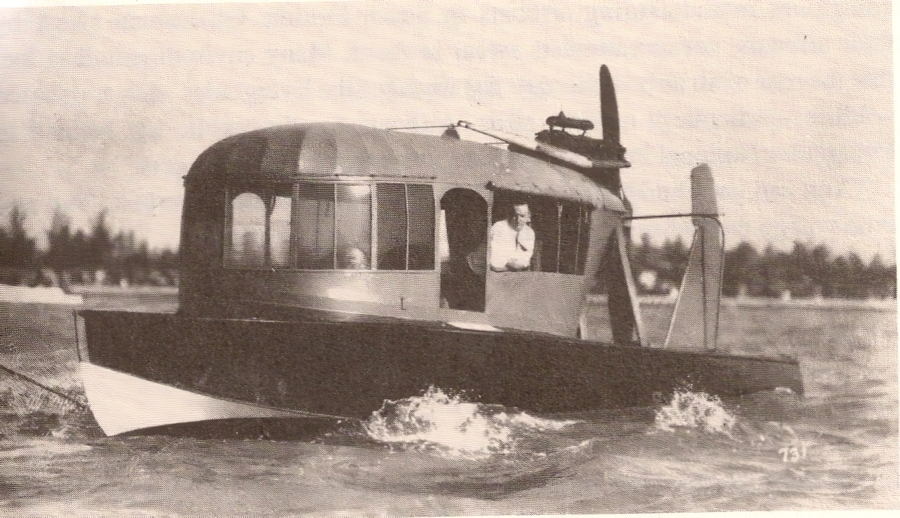 A vintage black and white photograph of one of the earliest airboat navigating open water, showcasing the unique enclosed cabin design and exposed propeller, representing the historical evolution of airboats in Florida.